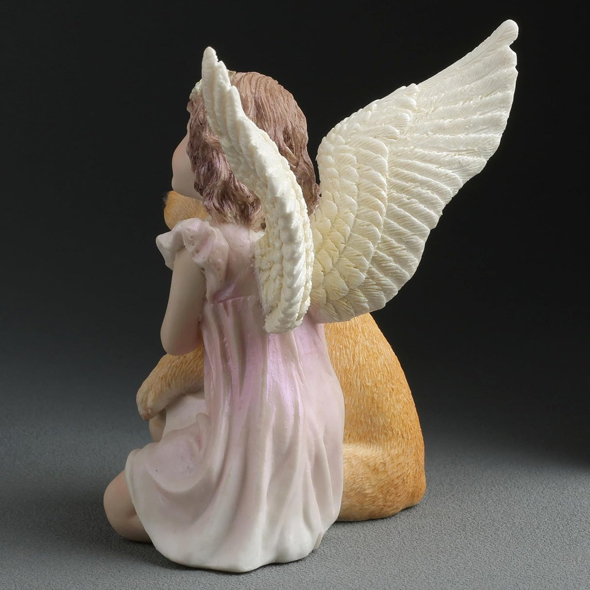 Angel figurine, angelic girl hugging a golden retriever puppy dog, shown from the back