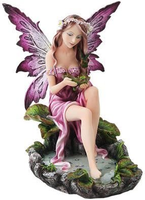 Fairy figurine, pink wings and dress, sitting with feet in pond and leaves in hand