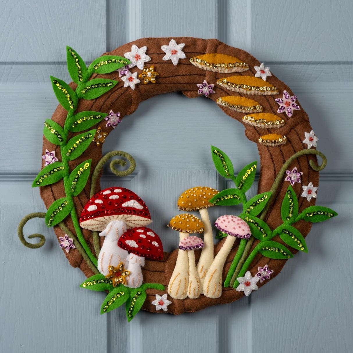 Decorative wreath with mushrooms and flowers on a blue door