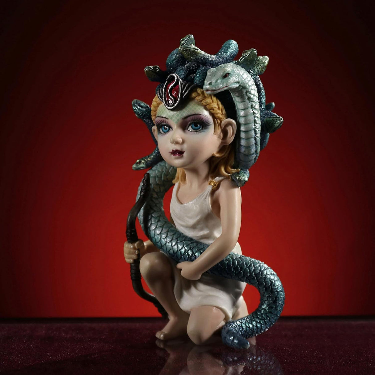 Figurine of Greek myth Medusa, woman with snakes for hair, holding a bow