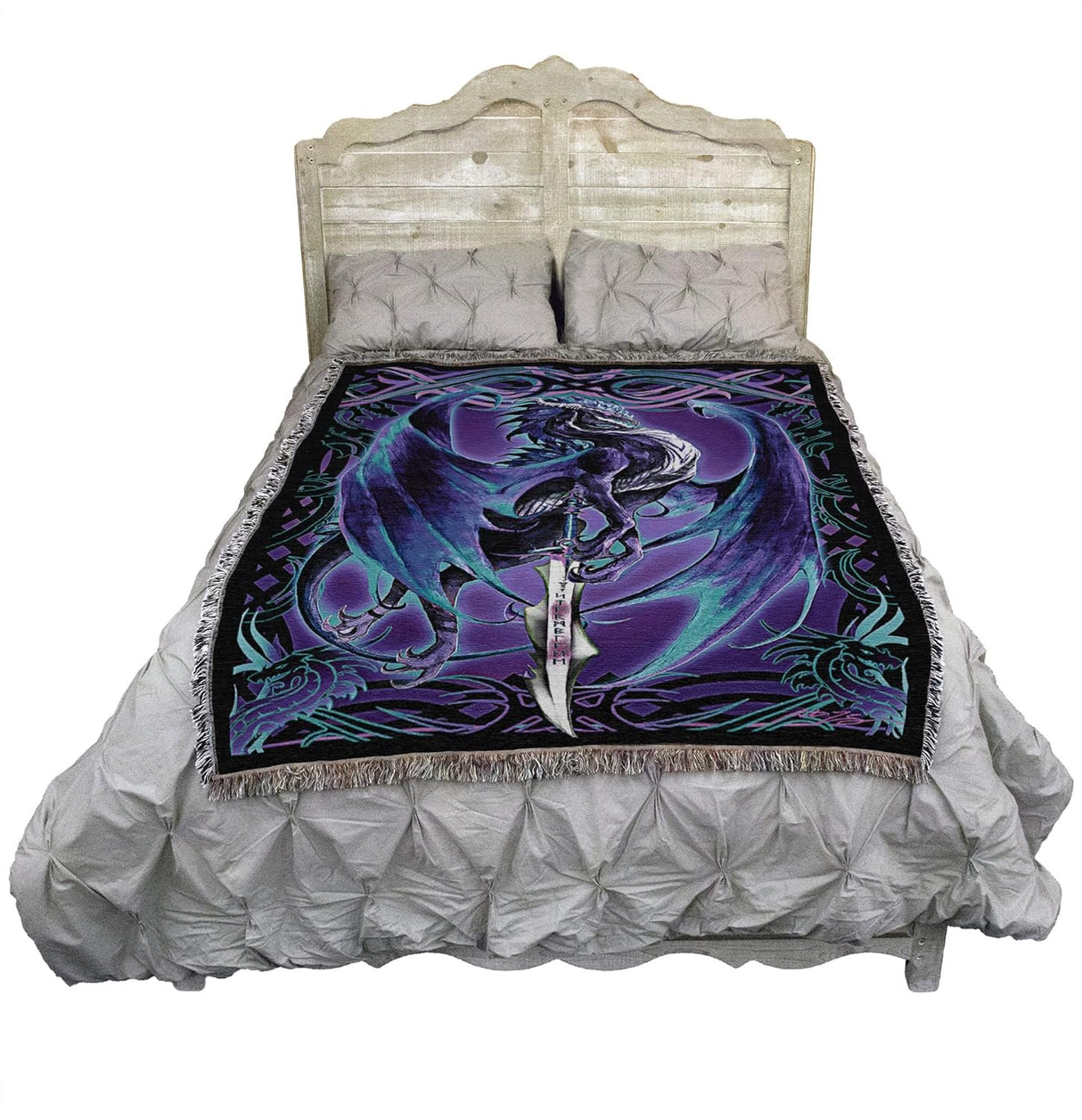 Bed with a decorative blanket featuring a purple and blue dragon design on a white background