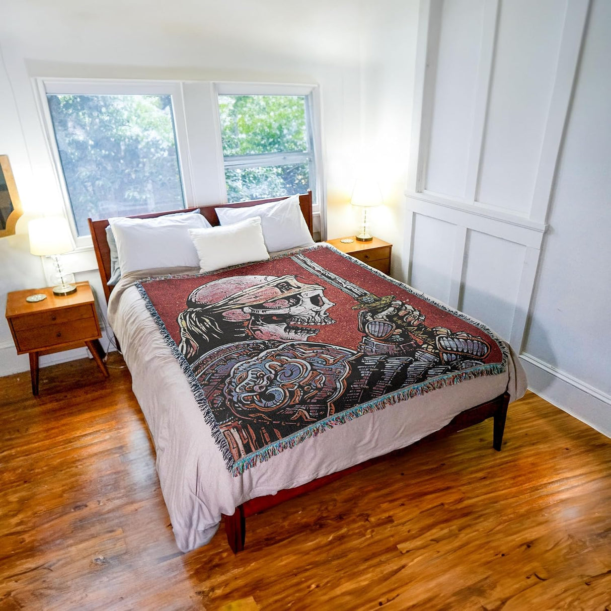 Bedroom with a bed featuring a decorative blanket with a samurai skeleton design.