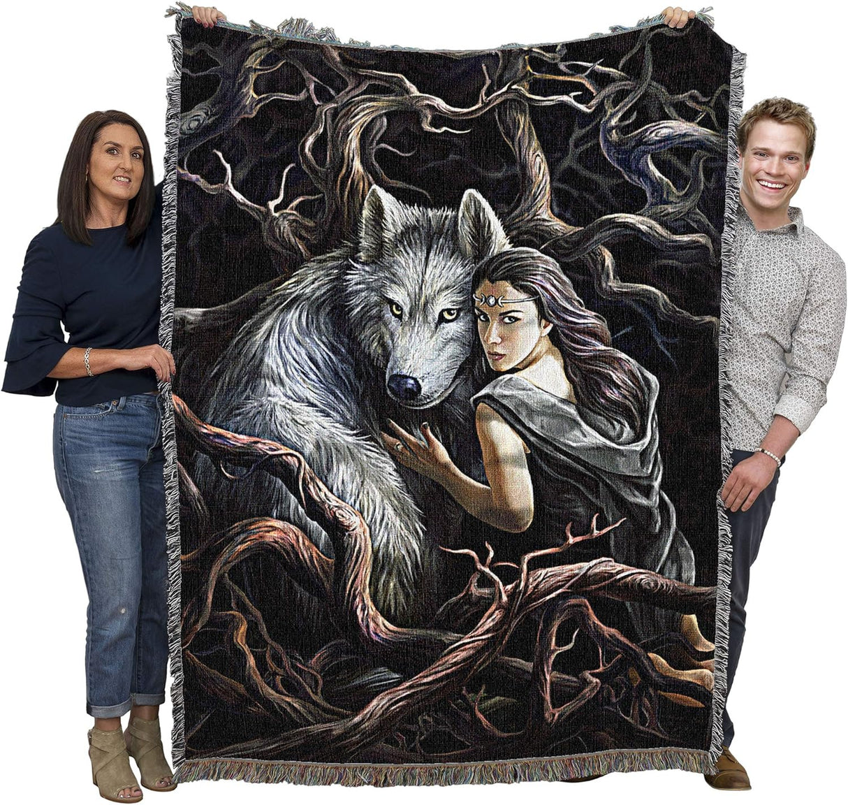 Tapestry blanket, black background, gray wolf with dark haired woman amidst vines and roots/branches, shown held by two adults to show large size