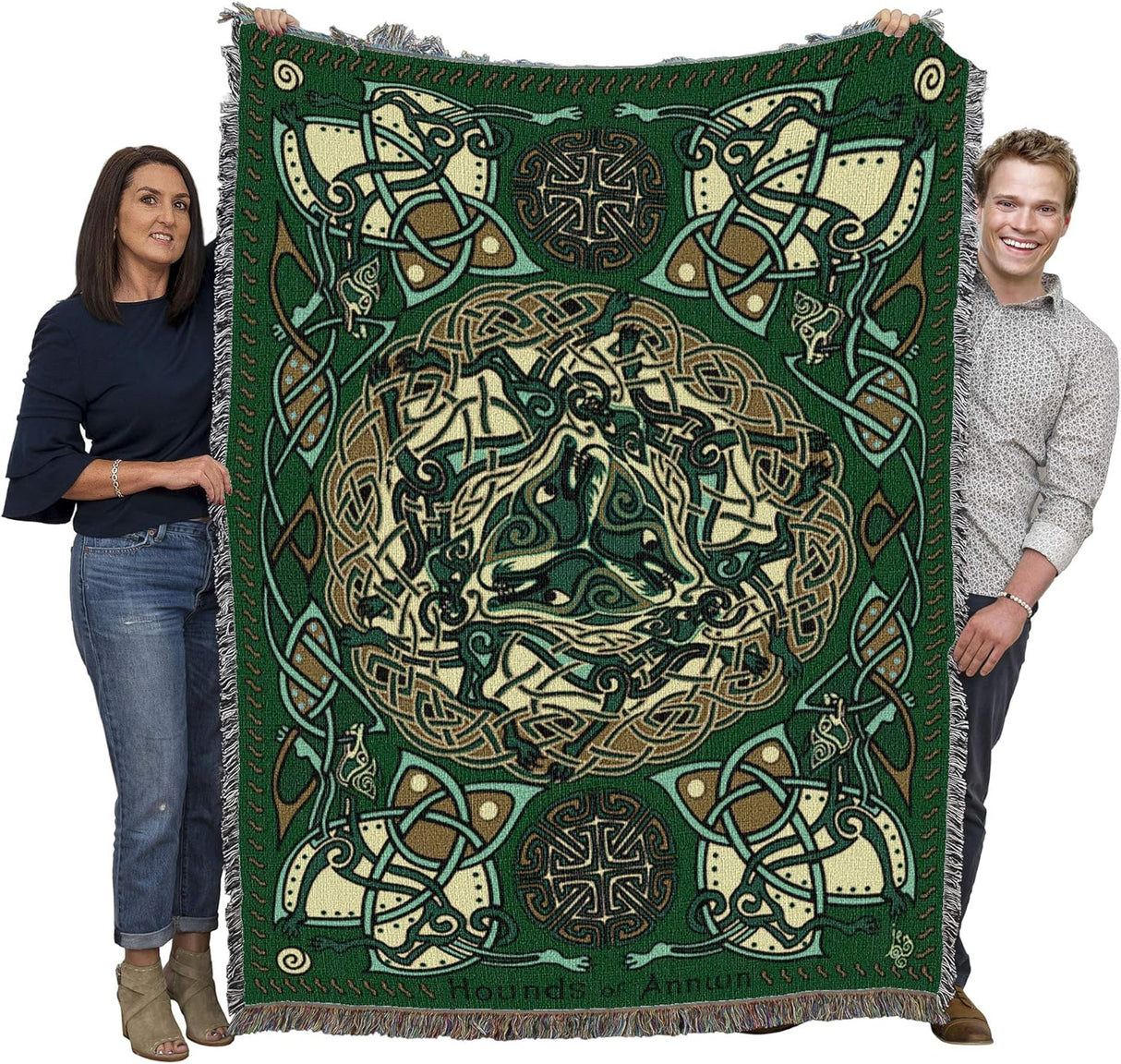 Tapestry blanket in green, gold and cream with Celtic hound knotwork design, held up by two people to show large size