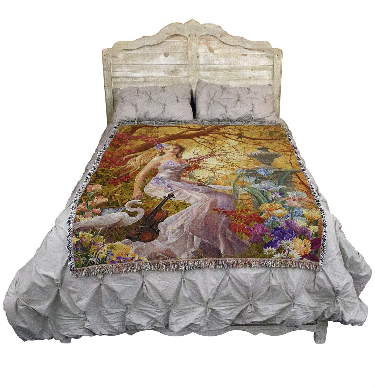 Tapestry blanket of a garden scene, blond lady in dress with violin, crane and bird next to iris and other flowers and stone statue, shown on a bed