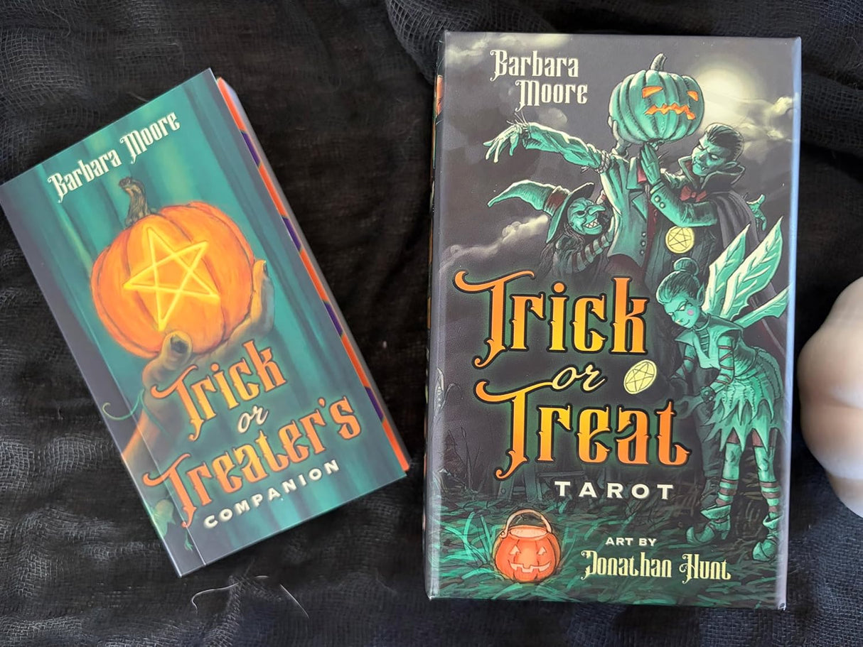 Trick or Treat Tarot deck with companion guide by Barbara Moore, displayed on a dark fabric background.