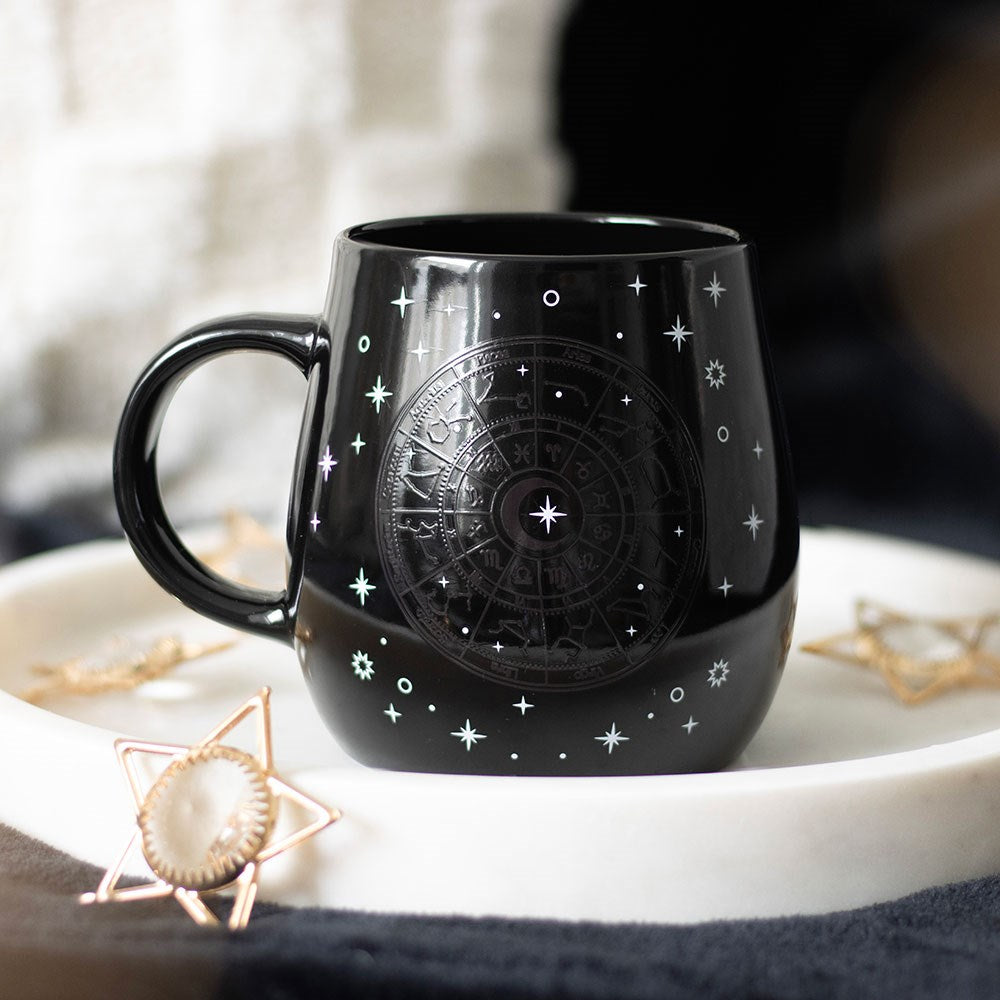 Black ceramic mug with gold astrology wheel that shows up with heat