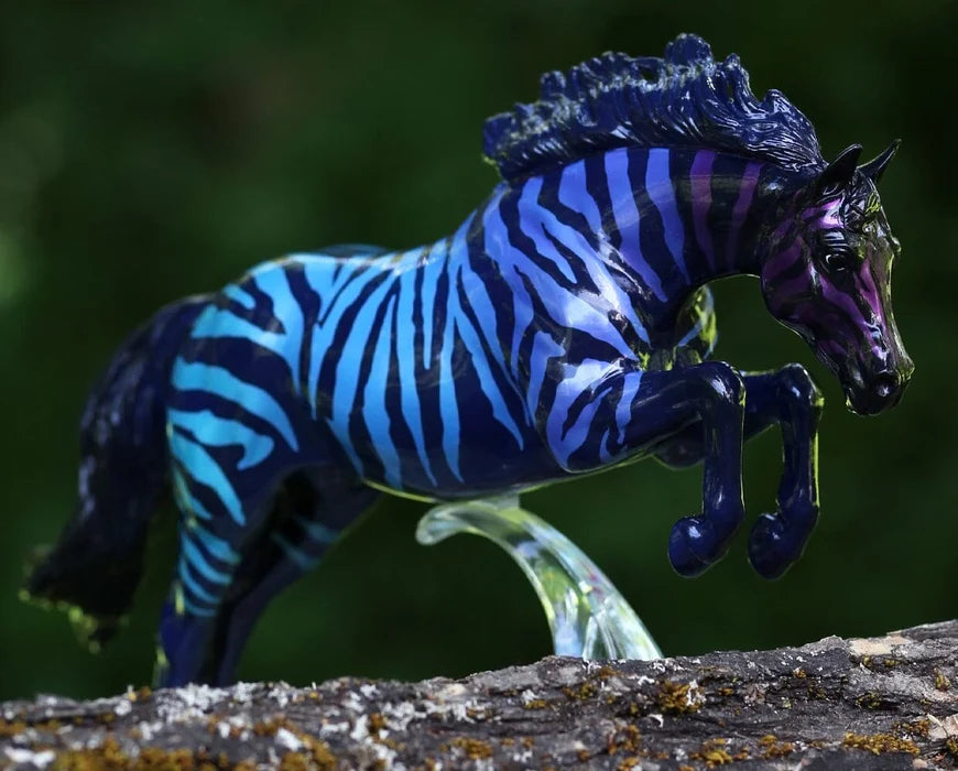 Breyer jumping horse figurine with zebra pattern in gradient purple-blue on black