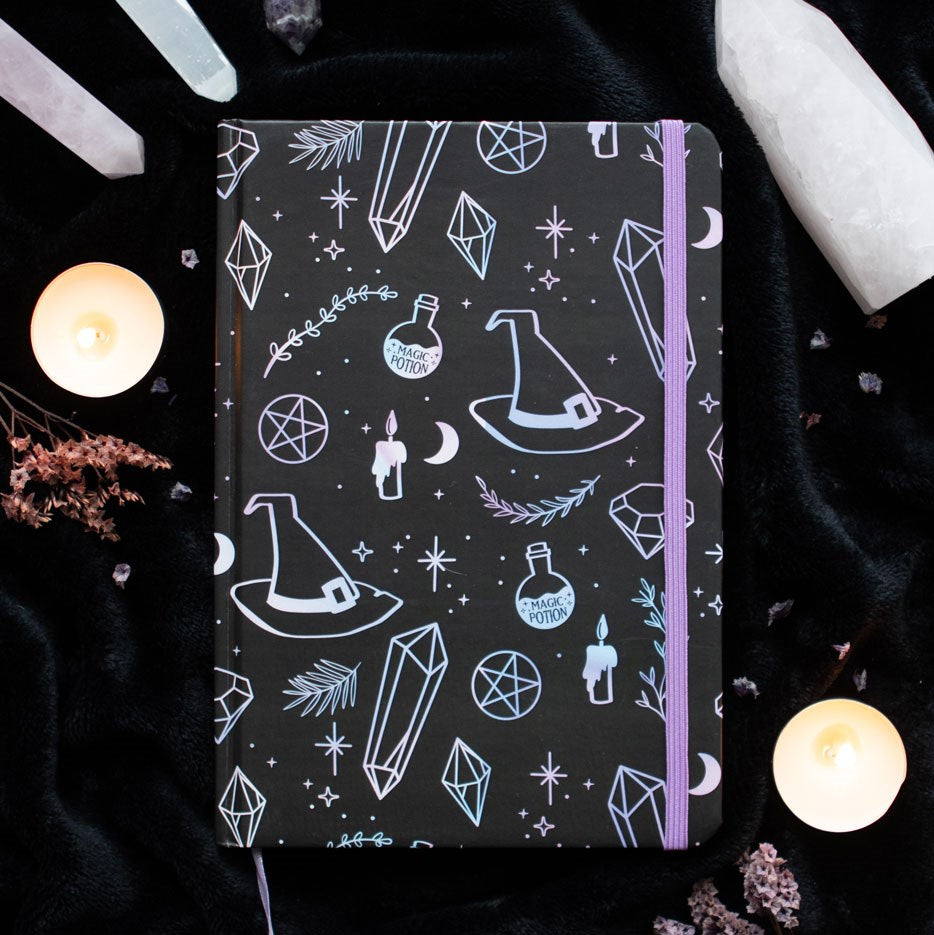 Journal with witchy designs - potion, hats, crystals, etc. Closed by lilac elastic ribbon