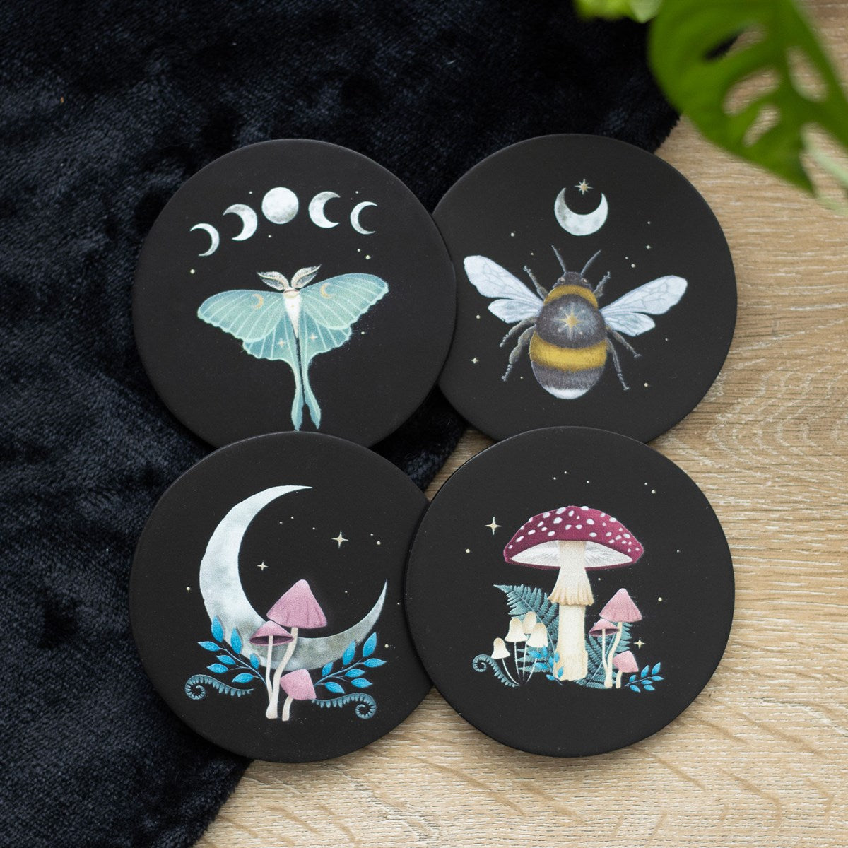 Set of four coasters, black background. 1 - mushrooms, 2 - luna moth with moon phases, 3 - crescent moon & mushrooms, 4 - bee and moon