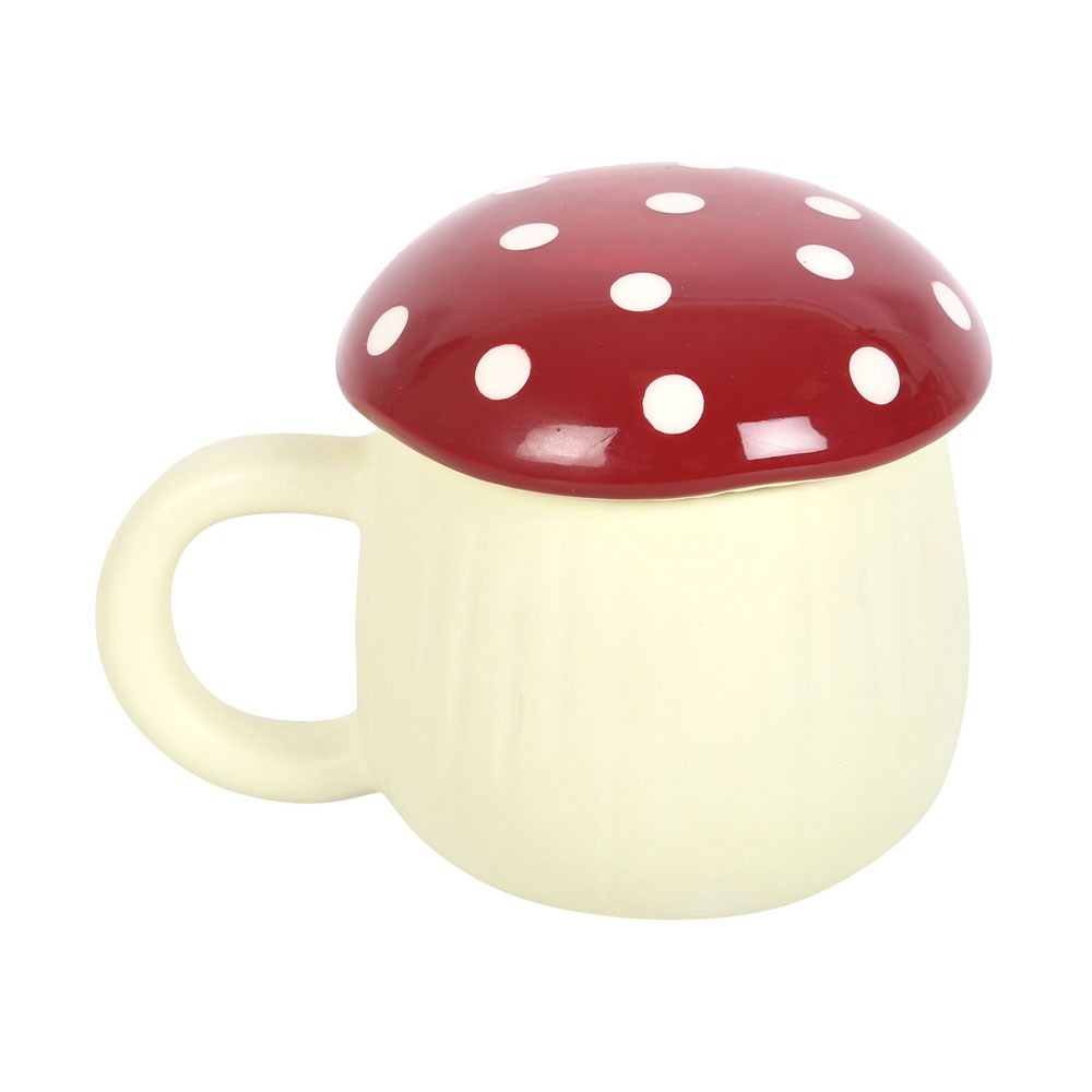 Mug in the shape of a mushroom. Mug itself and handle are white, lid is red with white dots