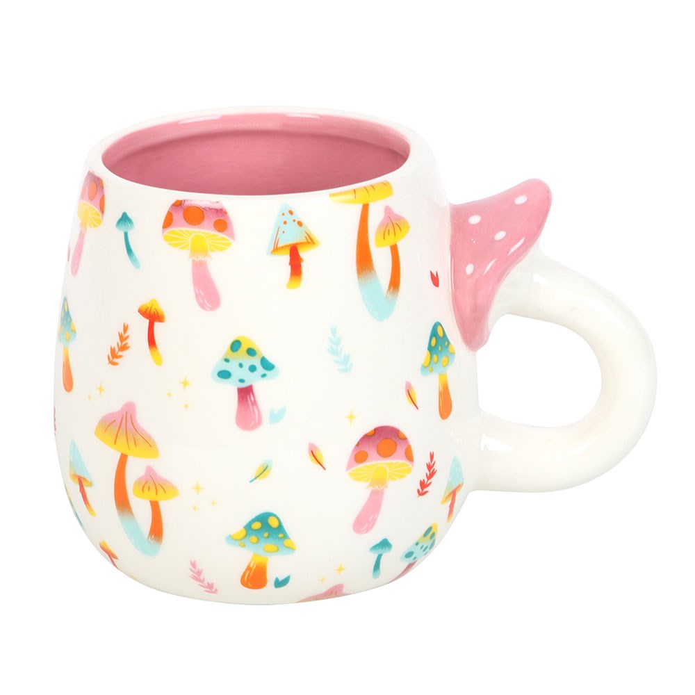 Ceramic mug with colorful mushroom patterns on the outside, handle shaped like a mushroom with a pink top with white spots, pink glaze inside the mug