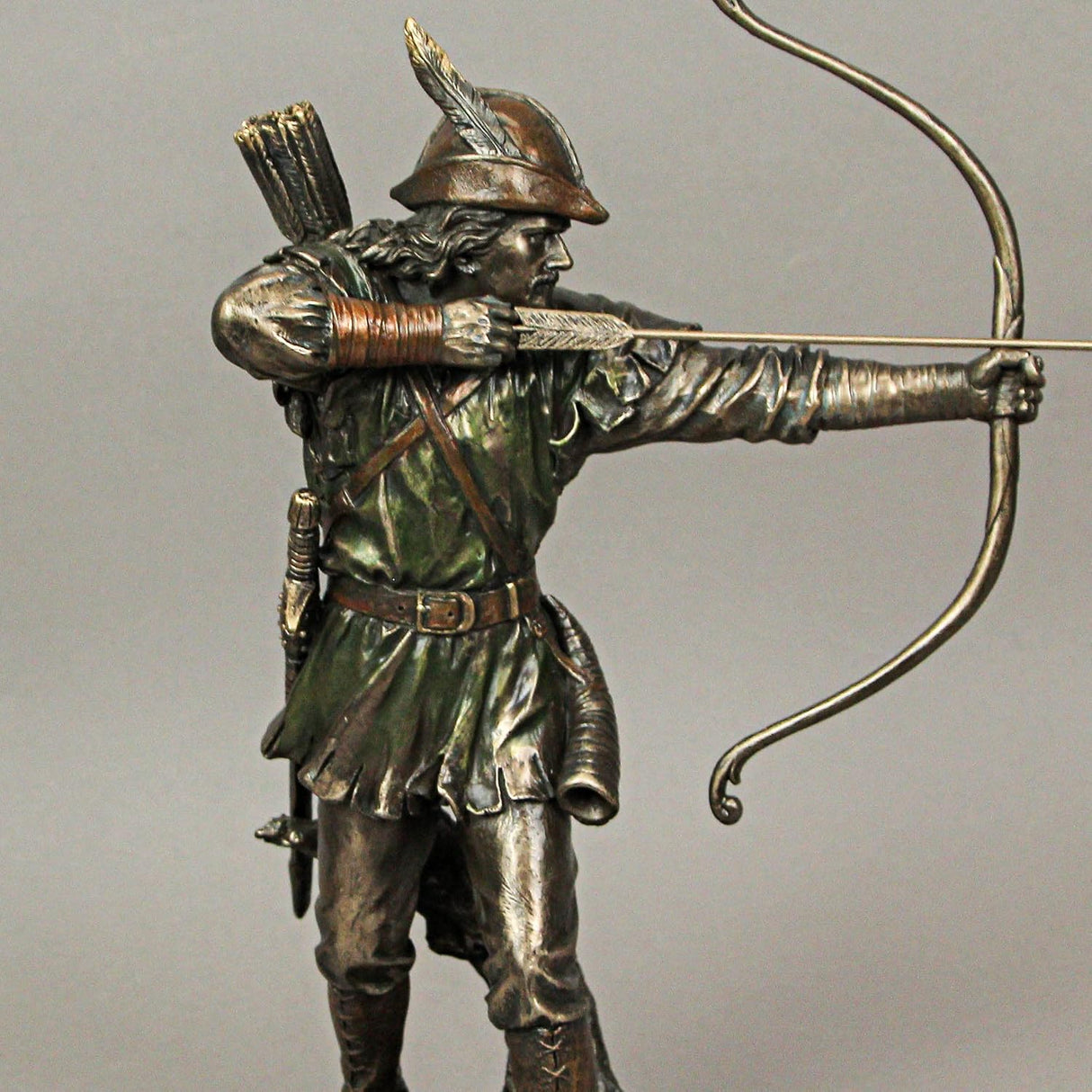 A bronze-hued figurine of Robin Hood drawing his bow with an arrow knocked