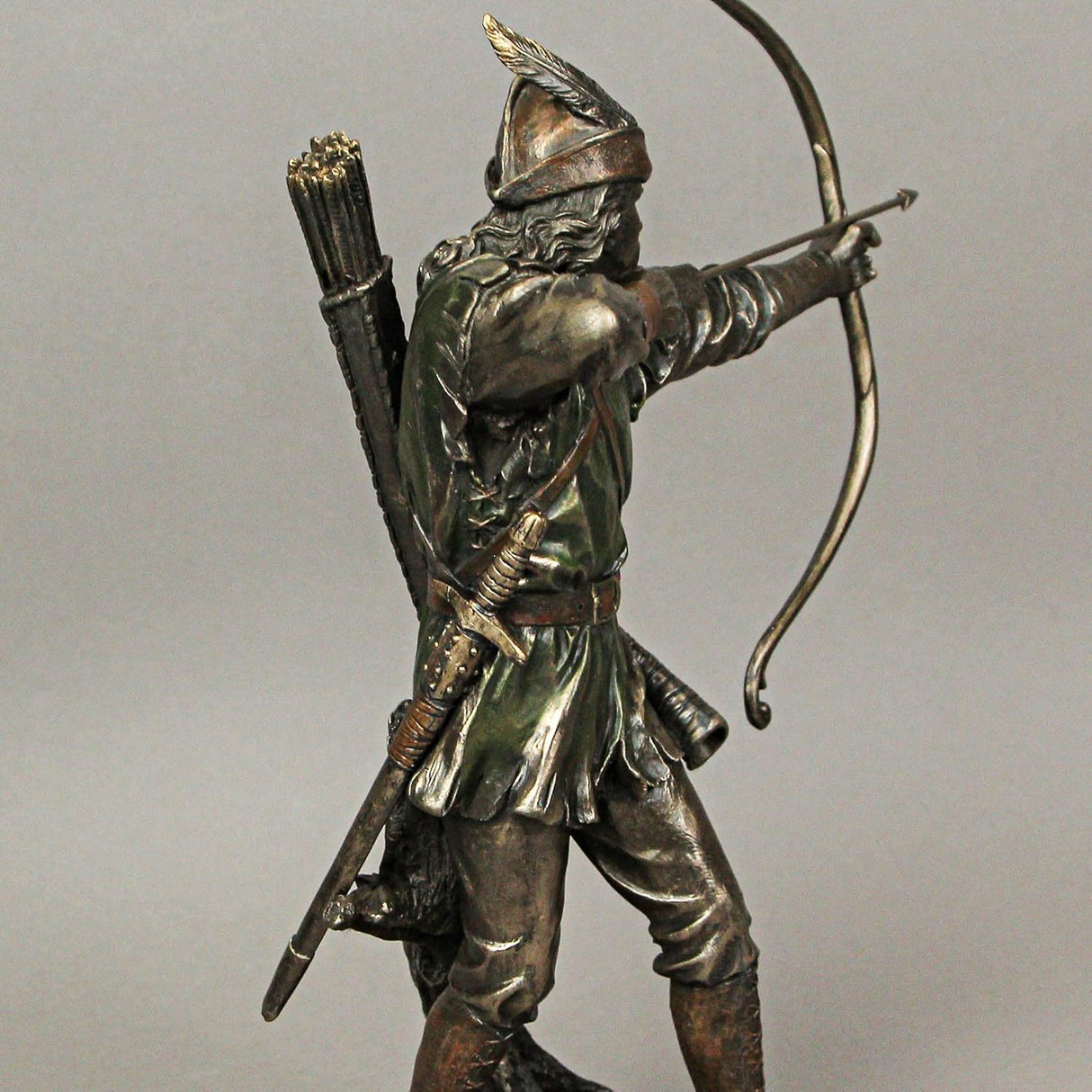 A bronze-hued figurine of Robin Hood drawing his bow with an arrow knocked