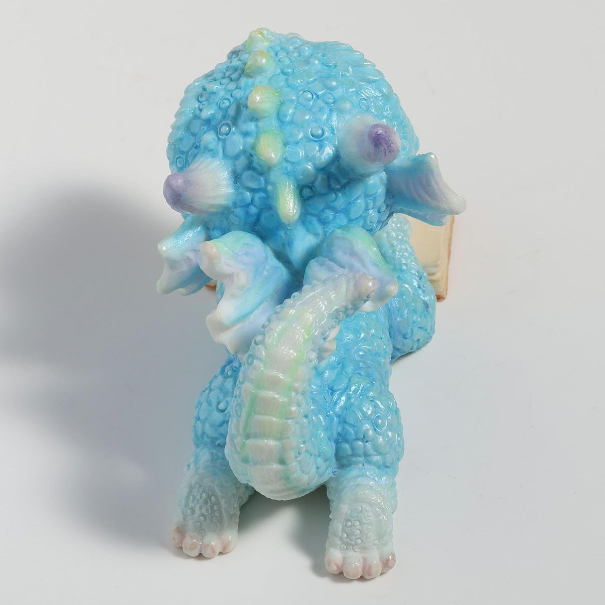 Blue dragon figurine with an open book