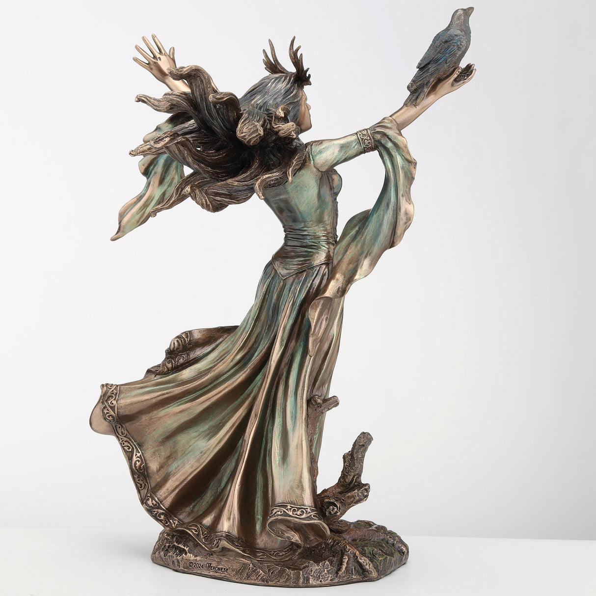 Figurine of the sorceress Morgan le Fey from Arthurian legend. Bronze hue with raven on arm, flowing dress and hair