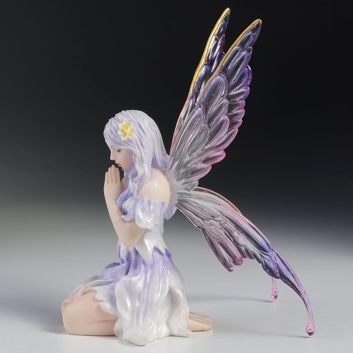 Fairy Figurine, pale purple hair and dress with hands clasped in front of her, eyes closed, transparent wings with shades of purple