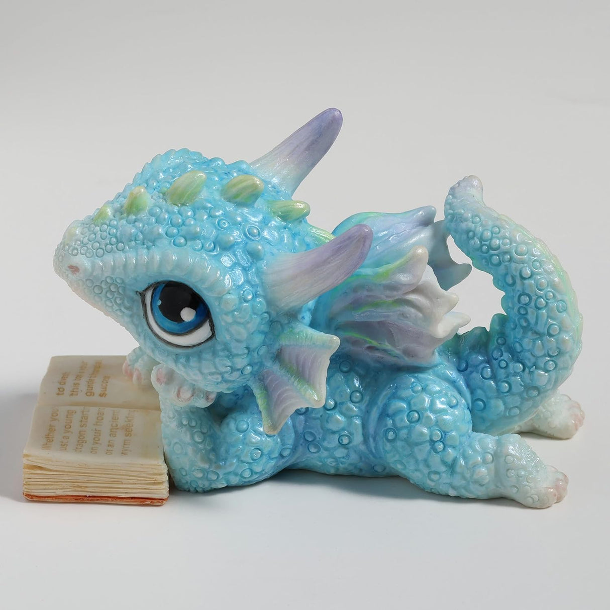 Blue dragon figurine with an open book