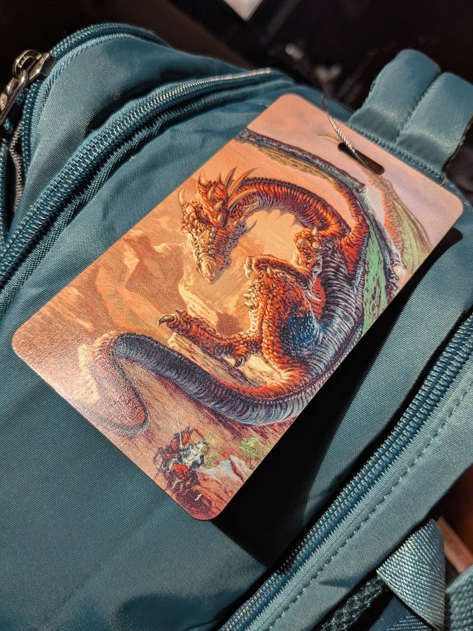 Luggage tag with a dragon and knight design on a teal suitcase