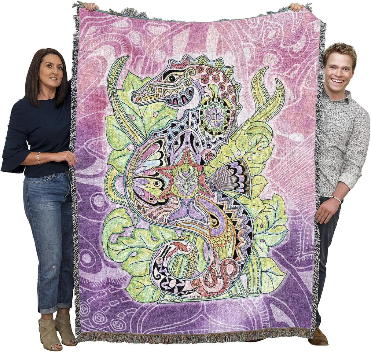 Two people holding a colorful tapestry with a seahorse design against a pink and purple patterned background.