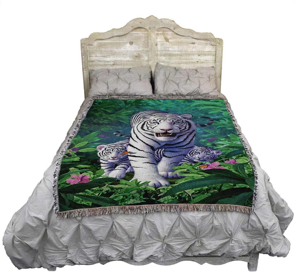 Bed with a decorative blanket featuring white tigers in a forest design.