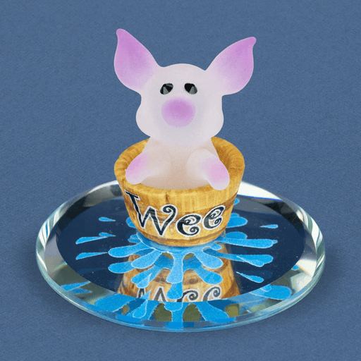 Glass figurine of pink frosted pig in a bucket that says "Wee" on a mirror with water decorations