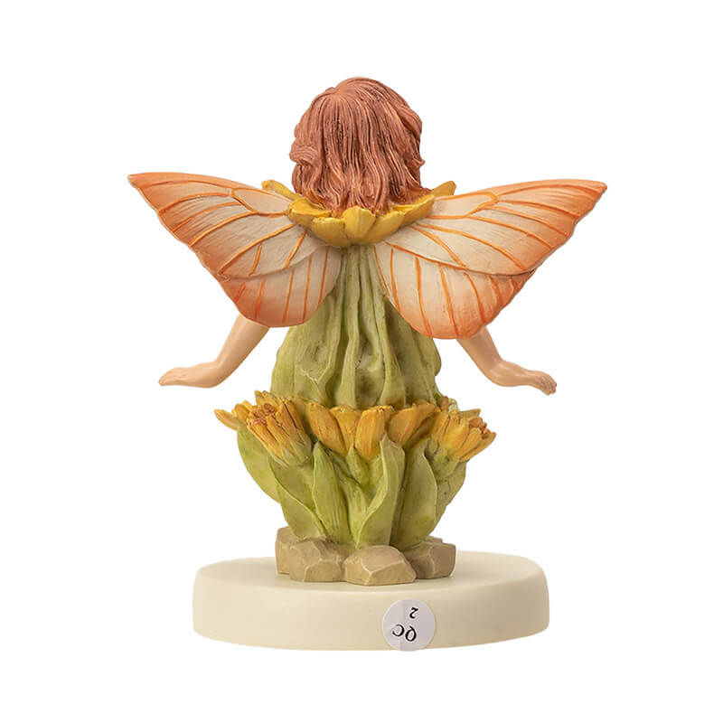 Flower fairy figurine of a pixie in pale green with yellow flower accents and peach-orange wings. Base says "Marigold Fairy"