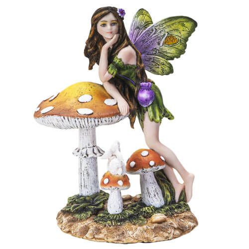 A fairy in green with a purple pouch standing leaning on a mushroom. On a toadstool below is a white bunny rabbit