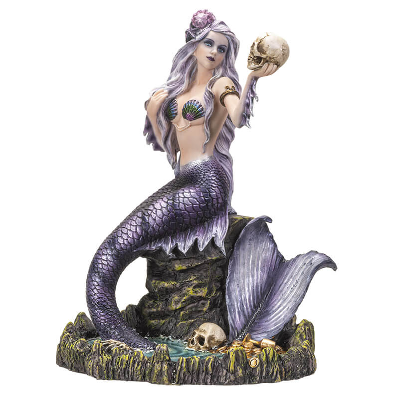 Mermaid holding up a skull figurine. Her scales are black and purple and she wears an iridescent seashell bra. Her hair is light violet with a shell. She sits on a rock with her tail in a pool of water, with another skull and golden treasures.