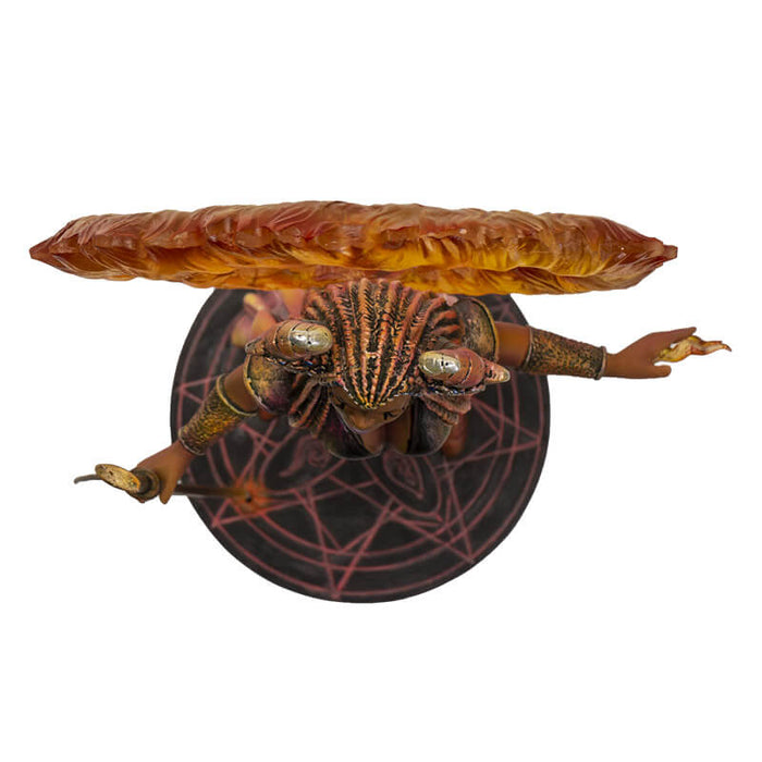 Fire Sorceress figurinec clad in red, orange and black clothes, holding a staff with a ring of fire around her horned head. Stands on black decorated base. Shown top-down from above