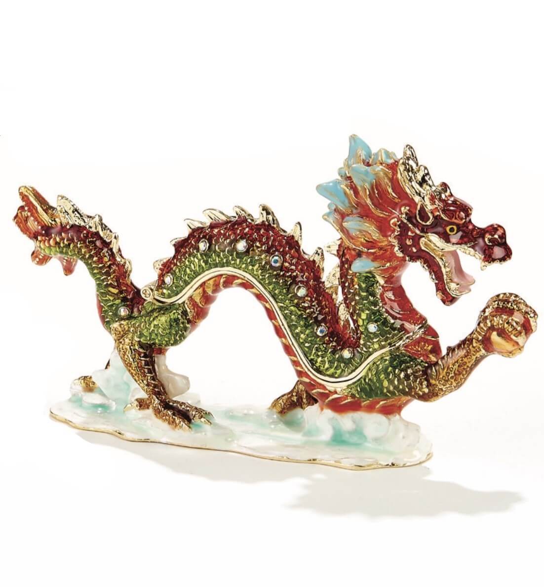 The enamel trinket box is shaped like an eastern style dragon, curving and graceful as it marches forward, mouth open and claw grasping an orb. Rich shades of ruby and emerald play along its back, and golden accents add a regal touch.