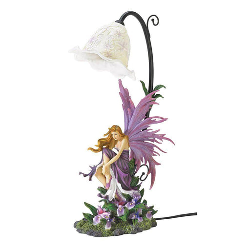 Fairy in purple with wings to match sits amongst the violet orchids. Above her is a lamp reminiscent of a lily of the valley blossom