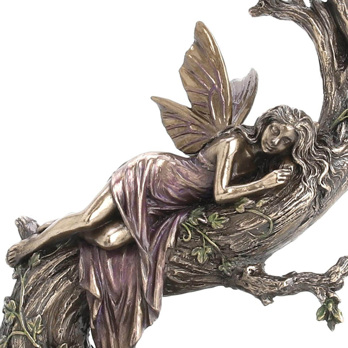 Close up - Fairy in pink dress slumbering on a tree with ivy vines above a pond. Done in metal colors with subtle hues overlaid. 
