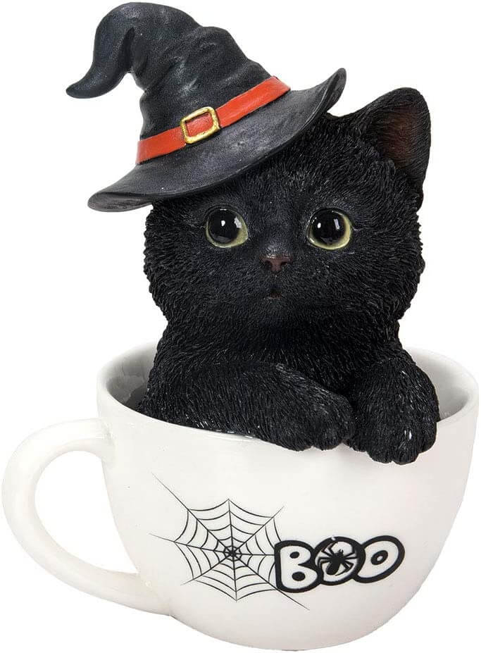 Black kitten in a white teacup. Cat wears a witch hat and the cup says "BOO" with a spiderweb