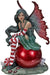 Fairy sitting on a red Christmas ornament. She wears a green dress with red & white striped stockings and sleeves and there is a peppermint nearby.