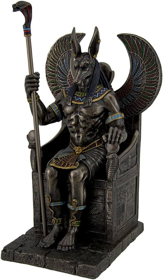Egyptian Jackal-headed god Anubis sitting in a throne with a snake-headed scepter