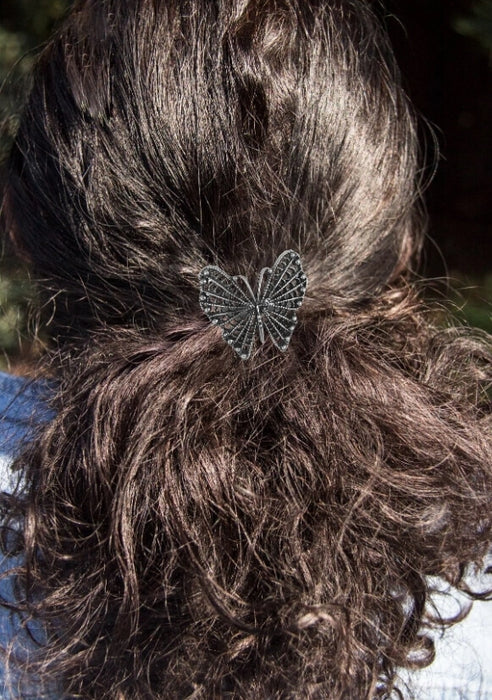Pewter butterfly ponytail holder shown in use on brunette hair