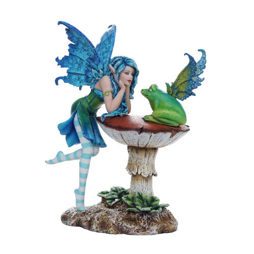 A figurine featuring a fairy with blue wings conversing with a green frog perched on a mushroom.