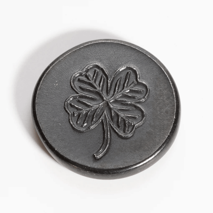 Black metal lucky coin showing clover