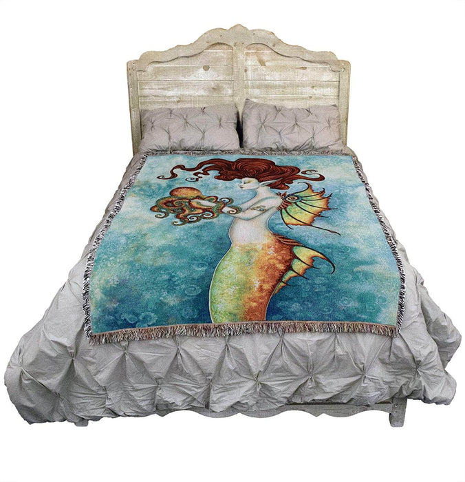 Mermaid and octopus tapestry displayed on a bed