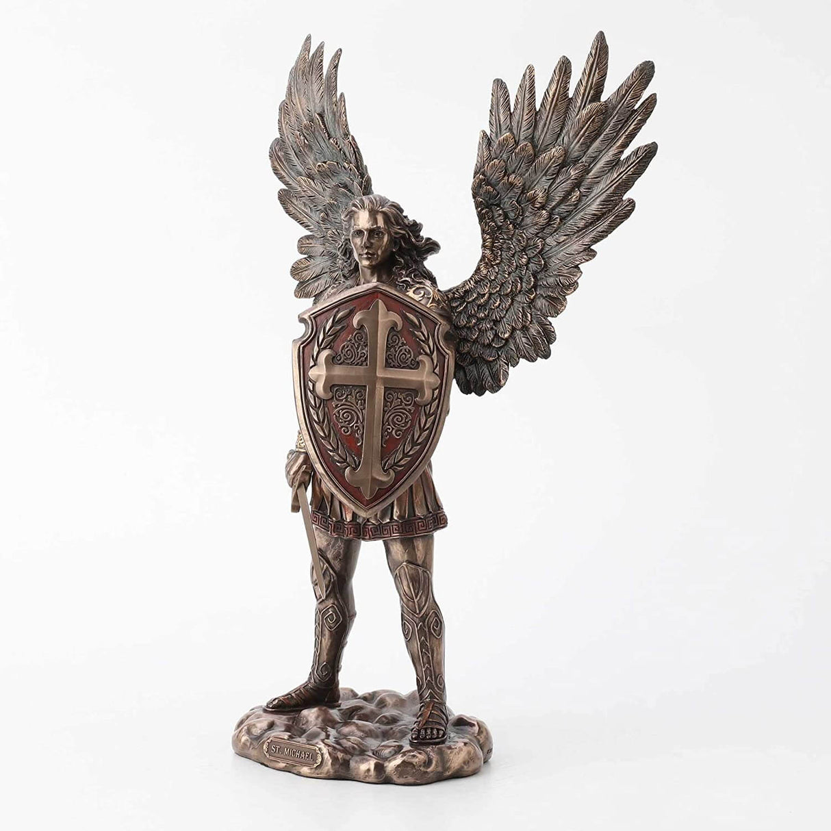 Saint Michael the archangel clad in battle armor with sword and shield and feathered wings. Shield has a cross upon it