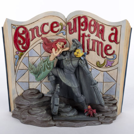 Figurine of Little Mermaid and Prince Eric statue with Sebastian the crab and Flounder against a storybook background