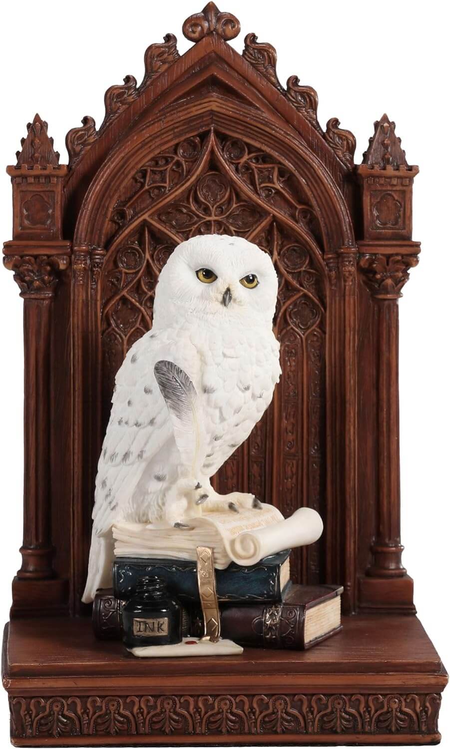 Snowy owl with golden eyes on bookstack holding quill, with faux-wood beyond