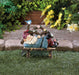 Solar garden ornament of gnome napping with light up bluebird on  a wooden bench