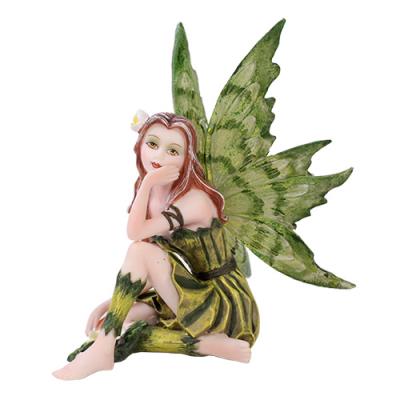 Fairy figurine with green wings and dress on a white background