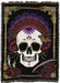 Tapestry blanket showing a grinning skull with flowers and a butterfly on a black background with gold border