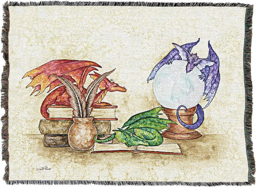 Tapestry blanket by Amy Brown with red, green and purple dragon hanging out on books near quills and crystal ball