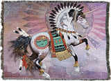 Tapestry blanket with black and white pinto horse sporting feather decorations, Native American and southwest designs, Kokopelli on sunset colored backdrop