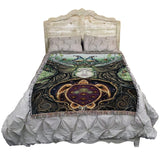 Tapestry with a turtle and face design on a white bed with wooden headboard