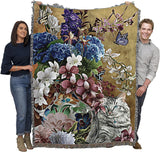 Tapestry blanket with blue eyed gray tabby cat and floral arrangement in a vase with butterflies. Shown held by two adults